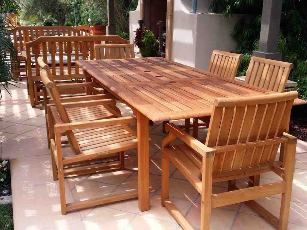 Teak outdoor dining table and chairs set on a patio showing natural wood grain and durable hardwood furniture for exterior use